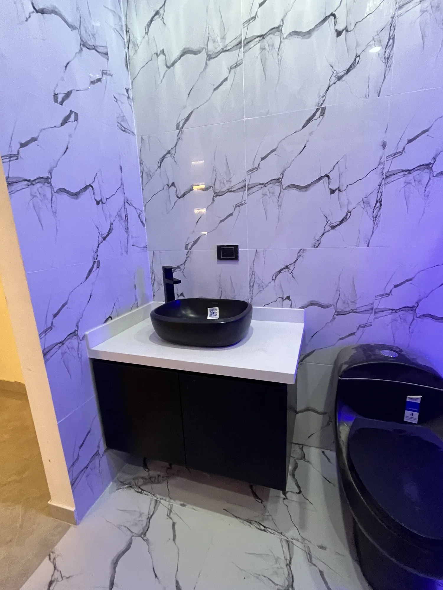 Baño remodelado por Droda con mueble de lavamanos y enchape tipo mármol