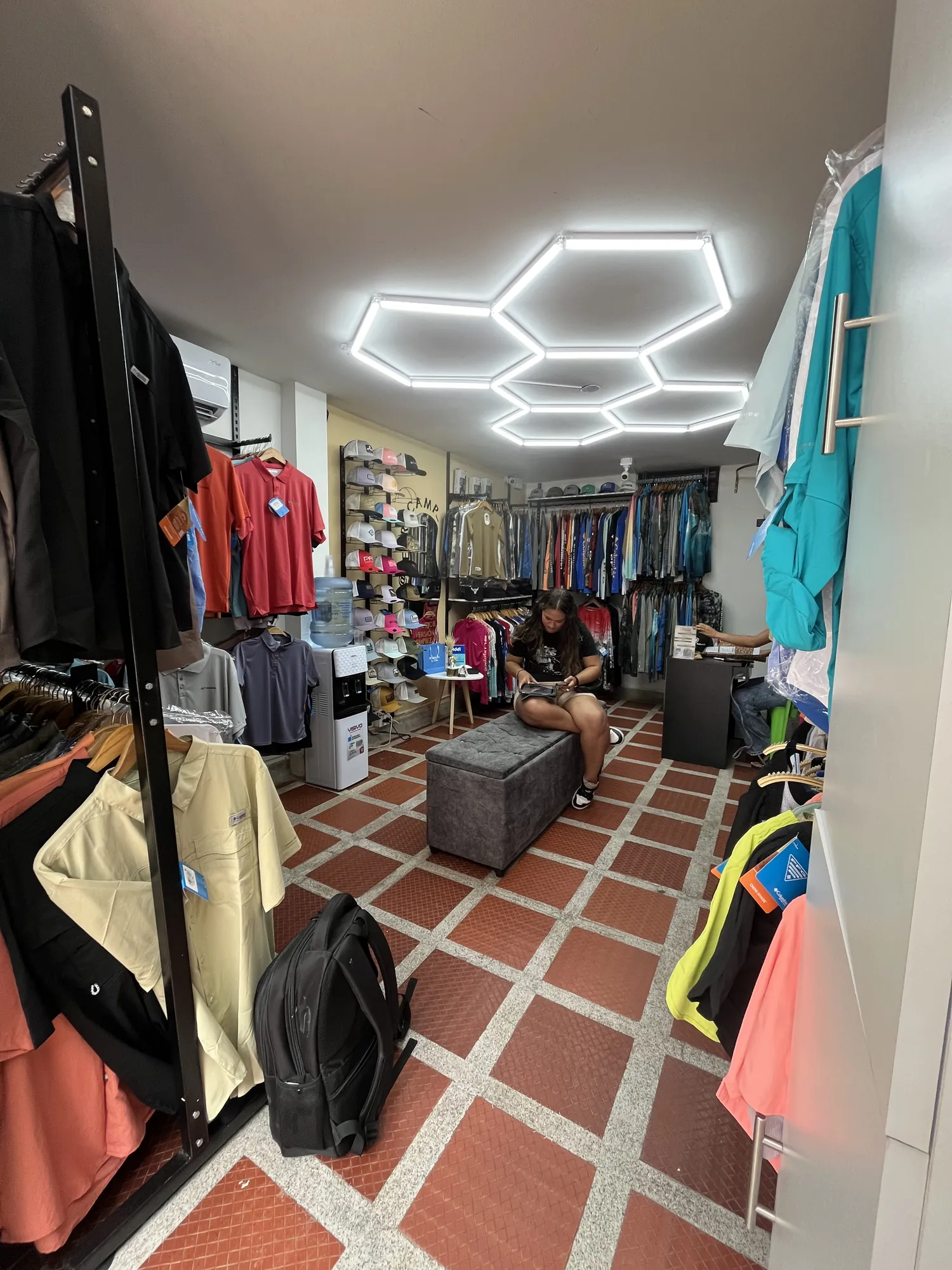 Local de ropa remodelado por Droda, con lámparas hexagonales en el techo